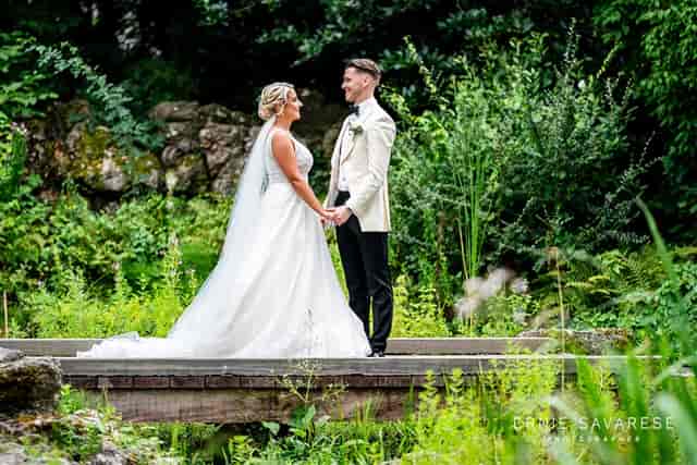 Intimate outdoor wedding at Tudor Barn Eltham with lush greenery backdrop.