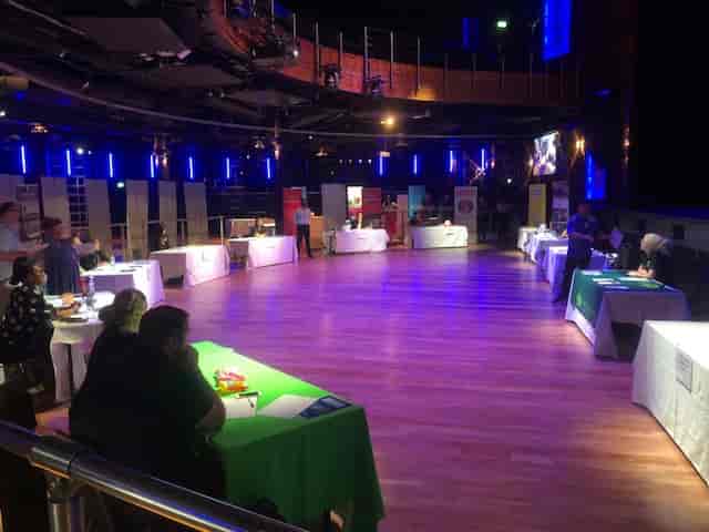 Spacious networking venue at The O2 with white-draped tables for exhibitions.
