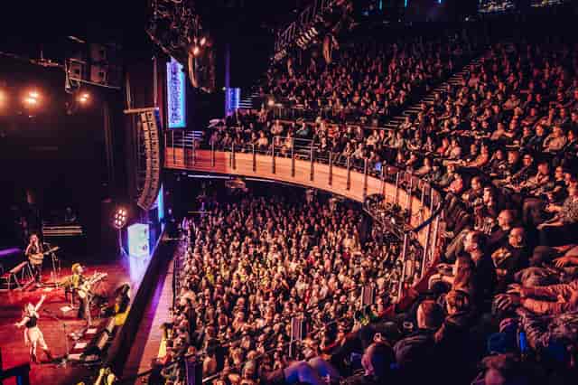 Packed audience enjoying a live performance at The O2's Main Area with vibrant stage lighting.