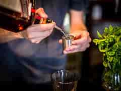Bartender crafting a cocktail with fresh mint at The Arcade, Four Thieves event.
