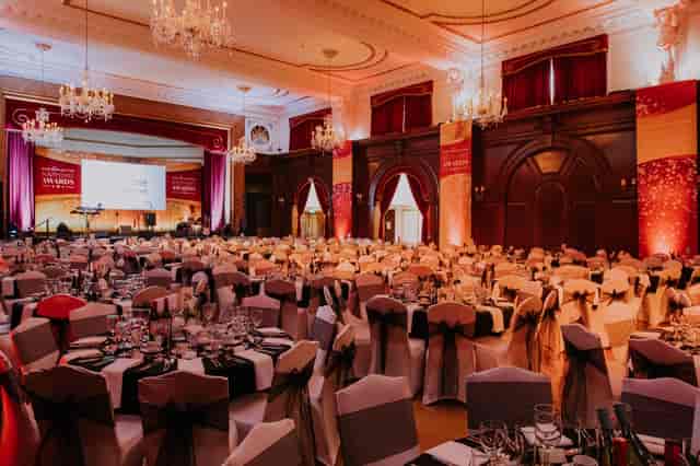 Elegant banquet hall with black and gold decor for corporate events and galas.