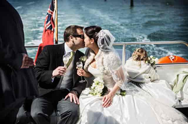 Couple celebrating wedding in Central Atrium, No Man's Fort, with elegant champagne toast.