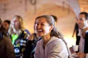 Lively meeting in No Man's Fort dining galley, featuring engaged attendees and laughter.