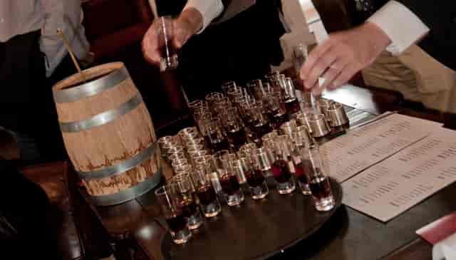 Boardroom tasting station with wooden barrel and shot glasses for networking events.