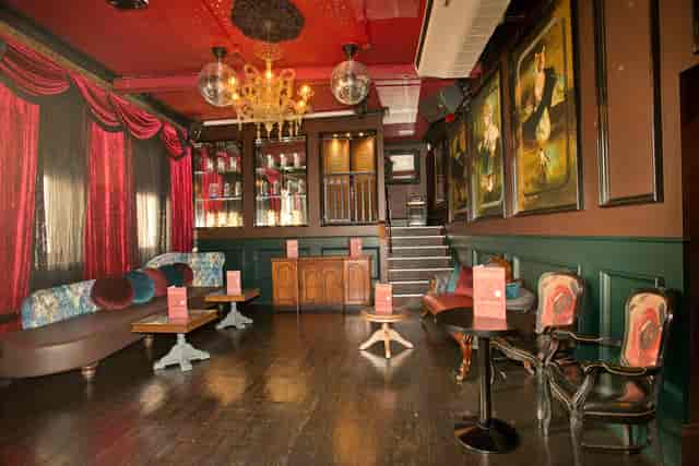 Stylish boudoir event space in Bar Soho with rich red drapery, perfect for gatherings.