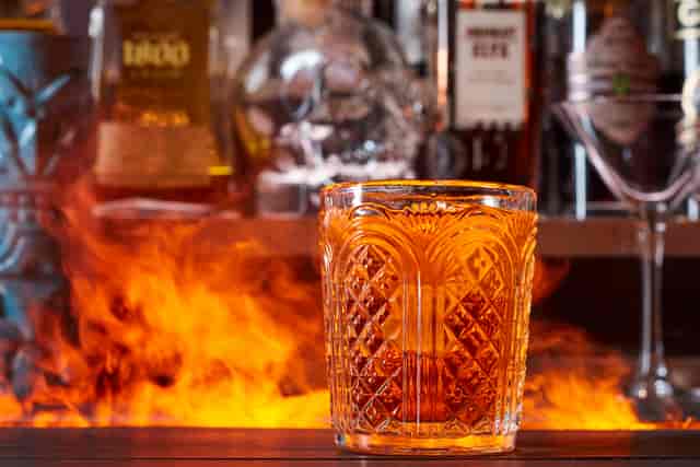 Whiskey glass in flames at ICE BAR London, ideal for upscale cocktail receptions.