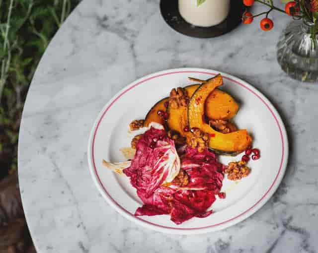 Roasted squash dish with radicchio, walnuts, and pomegranate for upscale events catering.