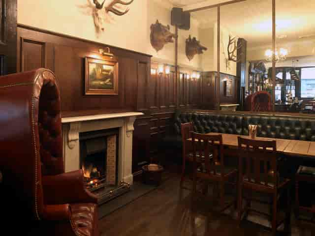 Cozy rustic venue with wood paneling for intimate meetings and small events.
