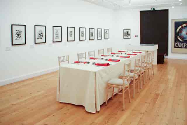 Elegant event space with long table, red accents for corporate meetings in Estorick Collection.