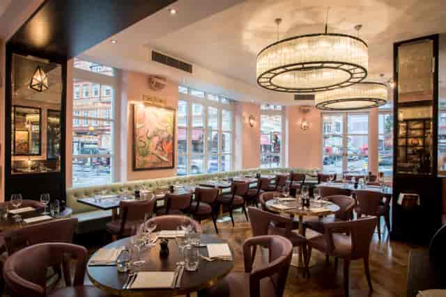 Stylish restaurant interior with modern chandeliers, ideal for corporate dinners and events.