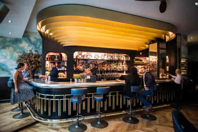Stylish bar area with gold ceiling, ideal for networking events and cocktail receptions.