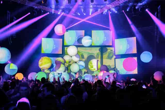 Vibrant Roundhouse event space with dynamic lighting and colorful projections.