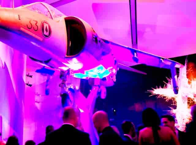 Harrier Jump Jet installation in vibrant purple lighting at Imperial War Museum North event space.