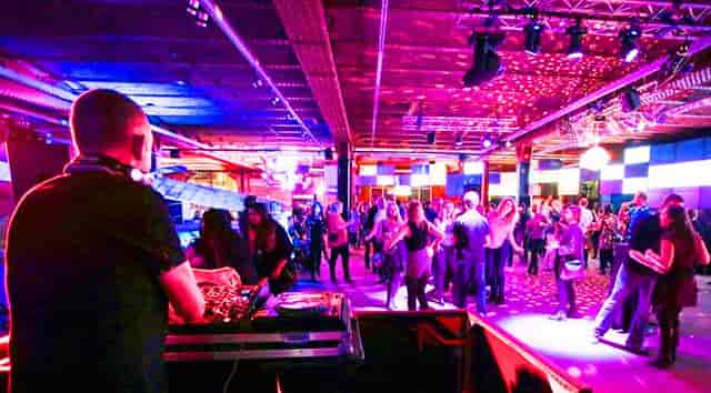 Vibrant Revolution Manchester Gallery event with dancing attendees and colorful lights.
