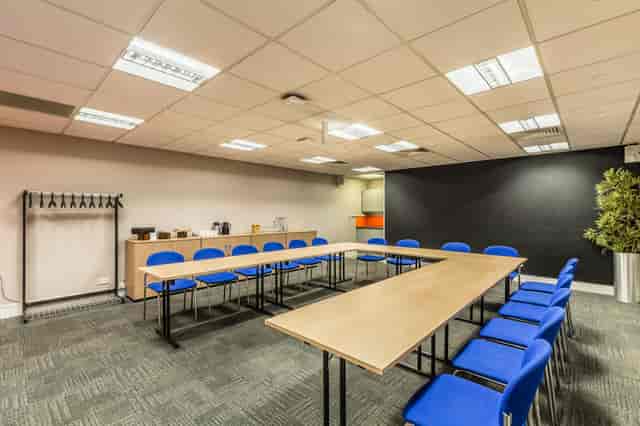 "Meeting room in BMA House with large table and blue chairs for workshops and collaboration."