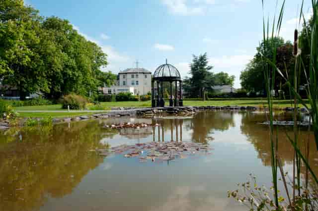 "Torintone Suite gazebo by tranquil pond, perfect for weddings and outdoor events."