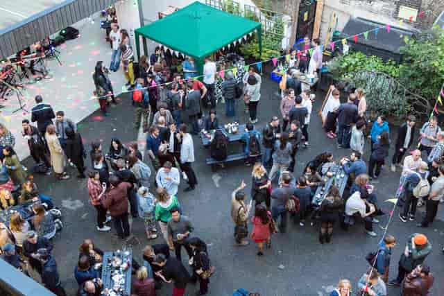 Vibrant outdoor networking event at Bow Arts Courtyard with colorful decorations.