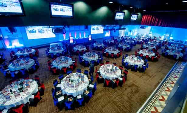 Event space at Villa Park with round tables, ideal for gatherings and presentations.