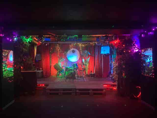 Vibrant event space with stage and colorful lighting for concerts and performances.