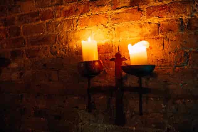 Cozy candlelit venue with rustic brick wall for intimate gatherings and events.