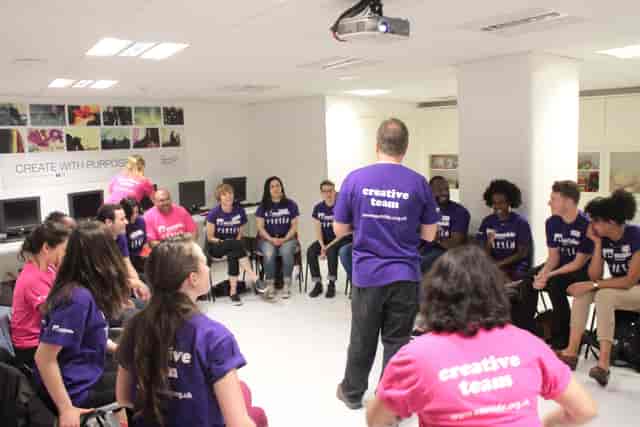 Team-building session in Shoreditch studio with vibrant shirts and circular seating.