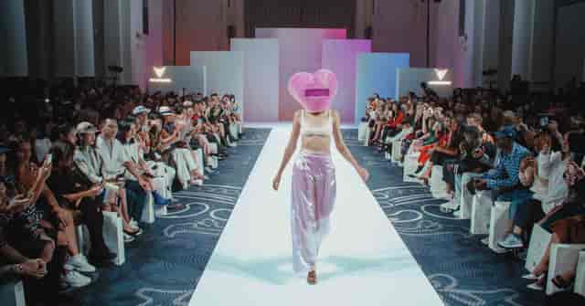 Fashion runway event at 8 Northumberland Avenue with model in heart-shaped headpiece.
