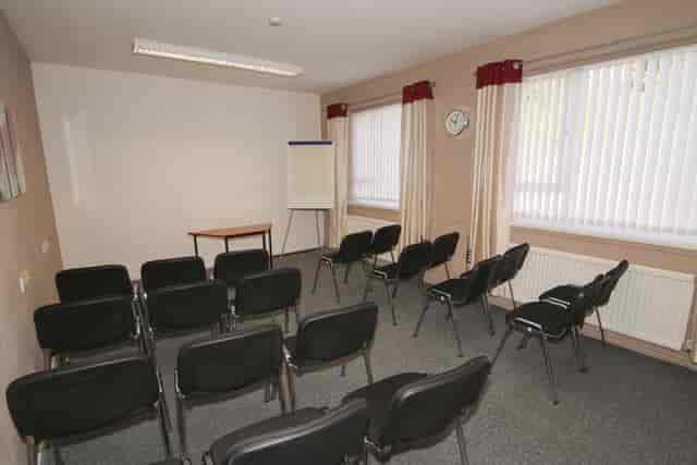 Meeting room at Ayton House with black chairs, ideal for presentations and discussions.
