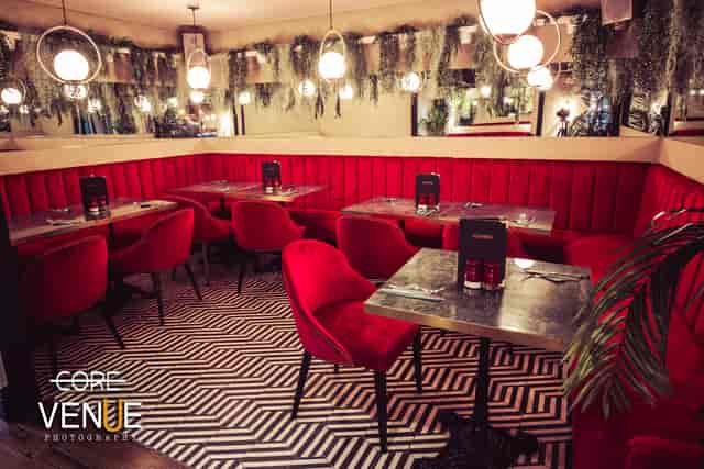 Stylish dining space with red seating, ideal for intimate gatherings and networking events.