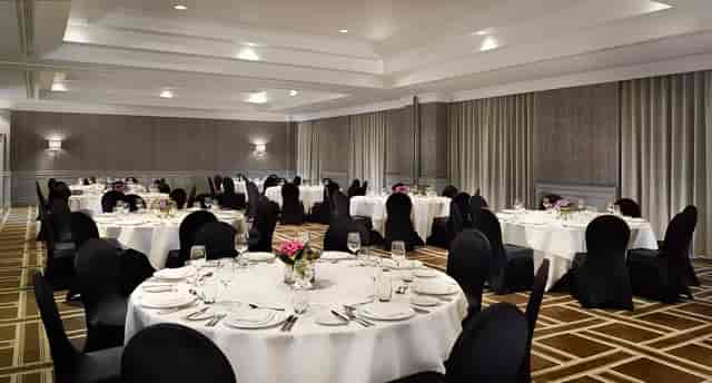 Elegant Symphony Ballroom setup for formal events with white tablecloths and floral centerpieces.