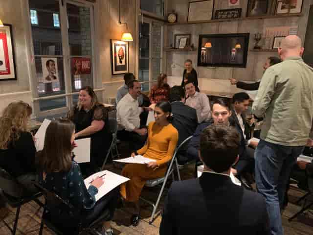 Networking event in cozy Yorkshire Grey meeting room with warm lighting.