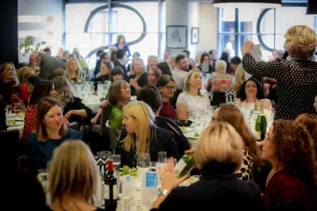 Vibrant networking event at Opus Restaurant with engaged attendees and elegant tables.