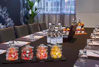 Mal One meeting room in Malmaison London with sleek black table and fresh fruit displays.