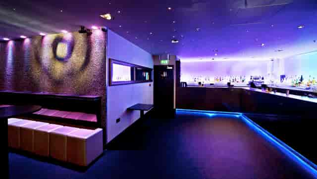 Modern event space with purple lighting, ideal for cocktail receptions and networking.