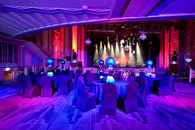 Christmas party gala at Troxy with elegant blue tables and dynamic stage lighting.