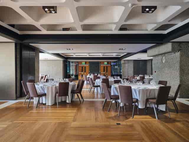 Elegant event space in Barbican Centre with round tables for corporate gatherings.