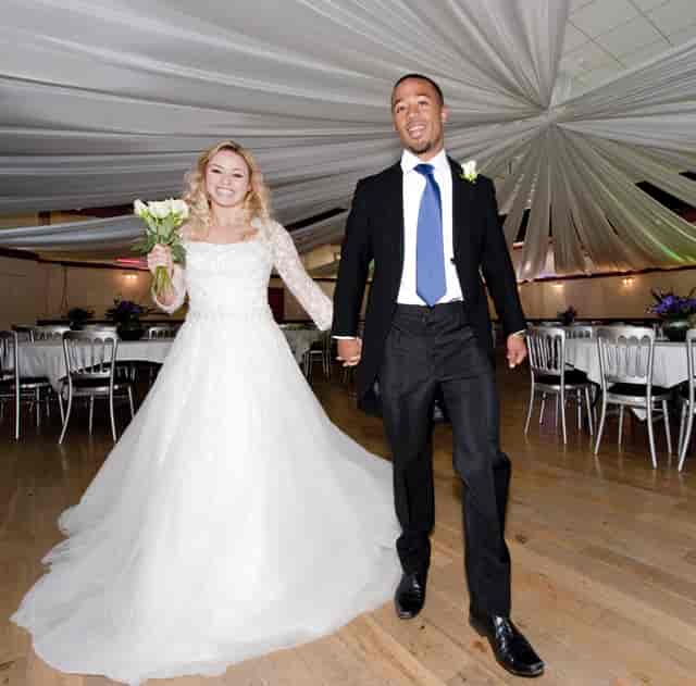 Joyful couple entering The Dray, a beautifully decorated wedding reception venue.