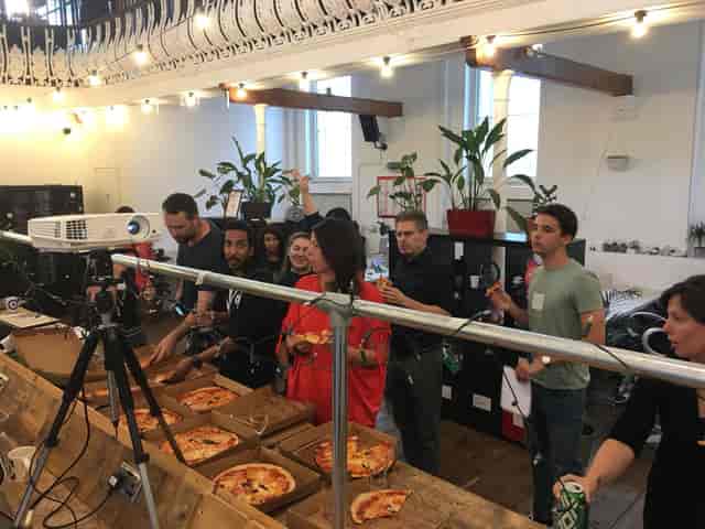 Casual networking event at Launch22 King's Cross with pizza and drinks in vibrant space.