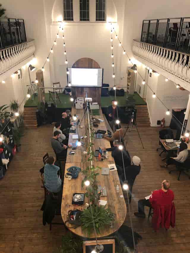 Collaborative meeting space at Launch22 King's Cross with wooden table and projector.