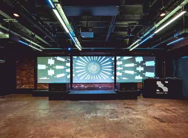 Versatile event space with sleek stage and large screens for conferences and performances.