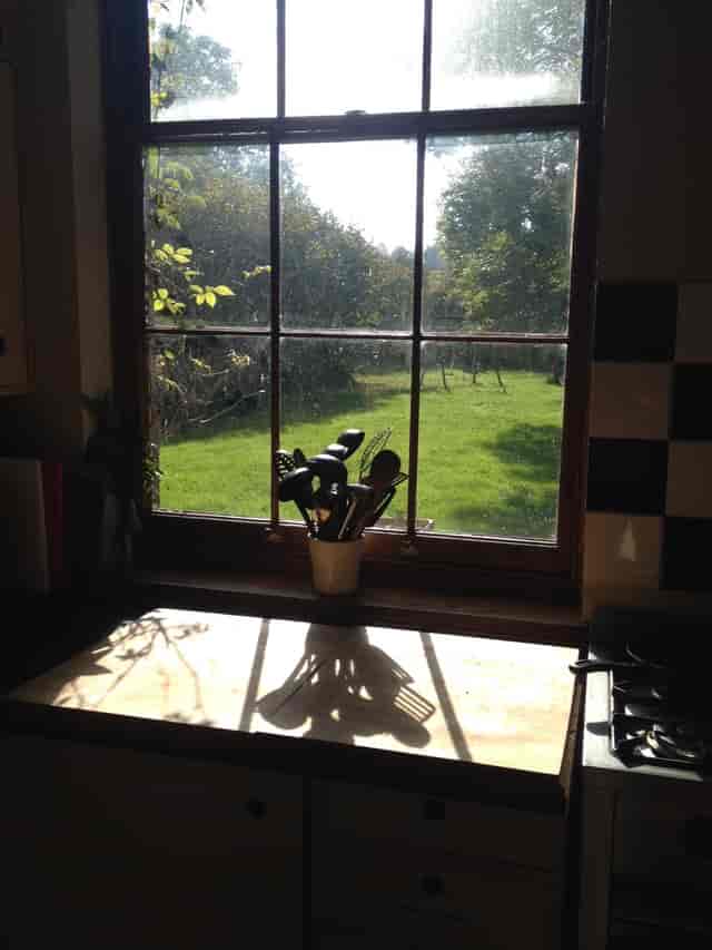 Serene farmhouse kitchen with sunlight, perfect for culinary workshops and gatherings.
