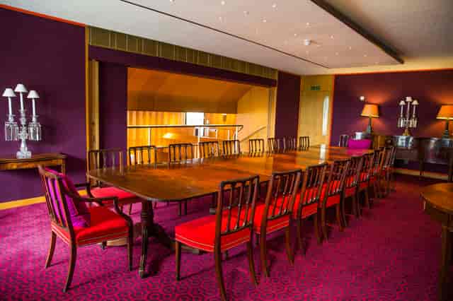 Elegant meeting room with wooden table and plush seating for formal events.