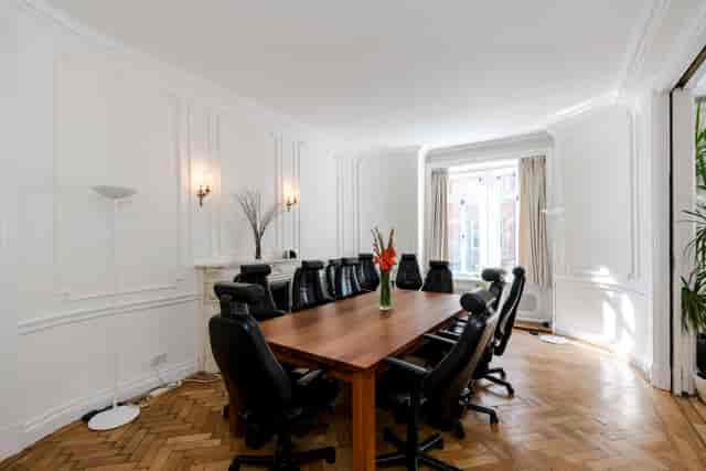 Boutique boardroom with wooden table, ideal for professional meetings and brainstorming sessions.