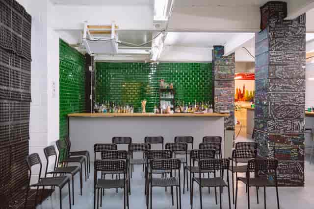 Main Room at London Bartender School with green bar, ideal for workshops and receptions.