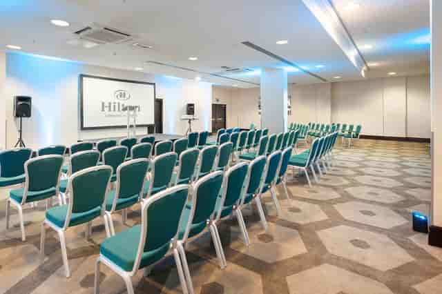 Westminster Suite at Hilton London Olympia, featuring teal chairs for corporate events.