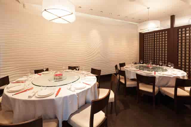 Private dining room with round tables, elegant decor for upscale events and intimate meetings.