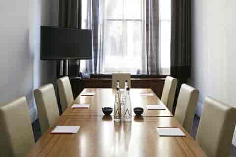 Private dining room with polished wooden table, ideal for corporate meetings and events.