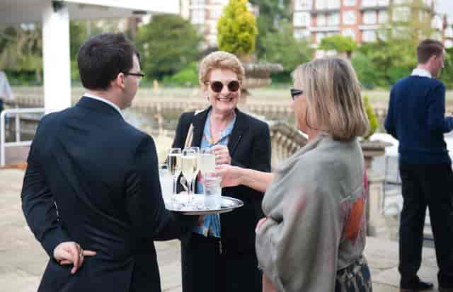 Outdoor reception at Ravens Ait Island with guests networking and enjoying drinks.