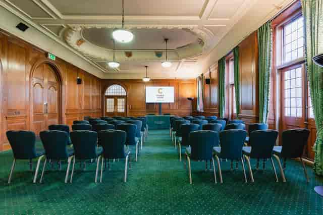 Wood-paneled Bishop Partridge Hall at Church House Westminster for formal corporate meetings.