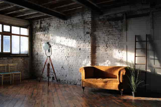 Stylish minimalist event space with vintage sofa, ideal for gatherings and workshops.