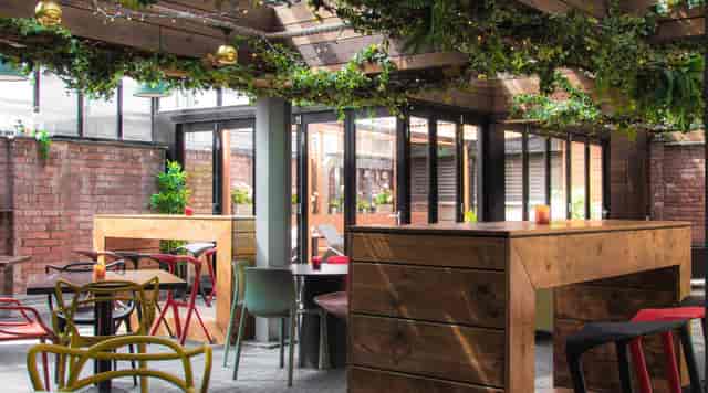Stylish Greenhouse event space with greenery, perfect for networking and social gatherings.
